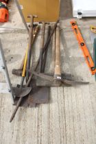 AN ASSORTMENT OF GARDEN TOOLS TO INCLUDE SPADES, A PICK AXE AND A SLEDGE HAMMER ETC