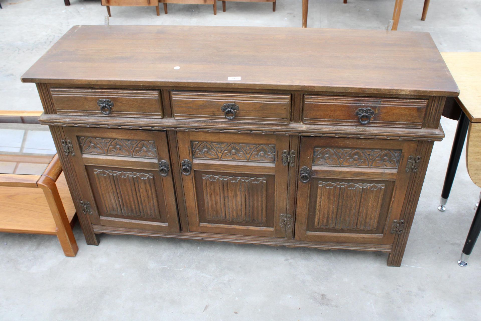 A REPRODUCTION OAK DRESSER WITH THREE LINENFOLD DOORS AND THREE DRAWERS, 54" WIDE