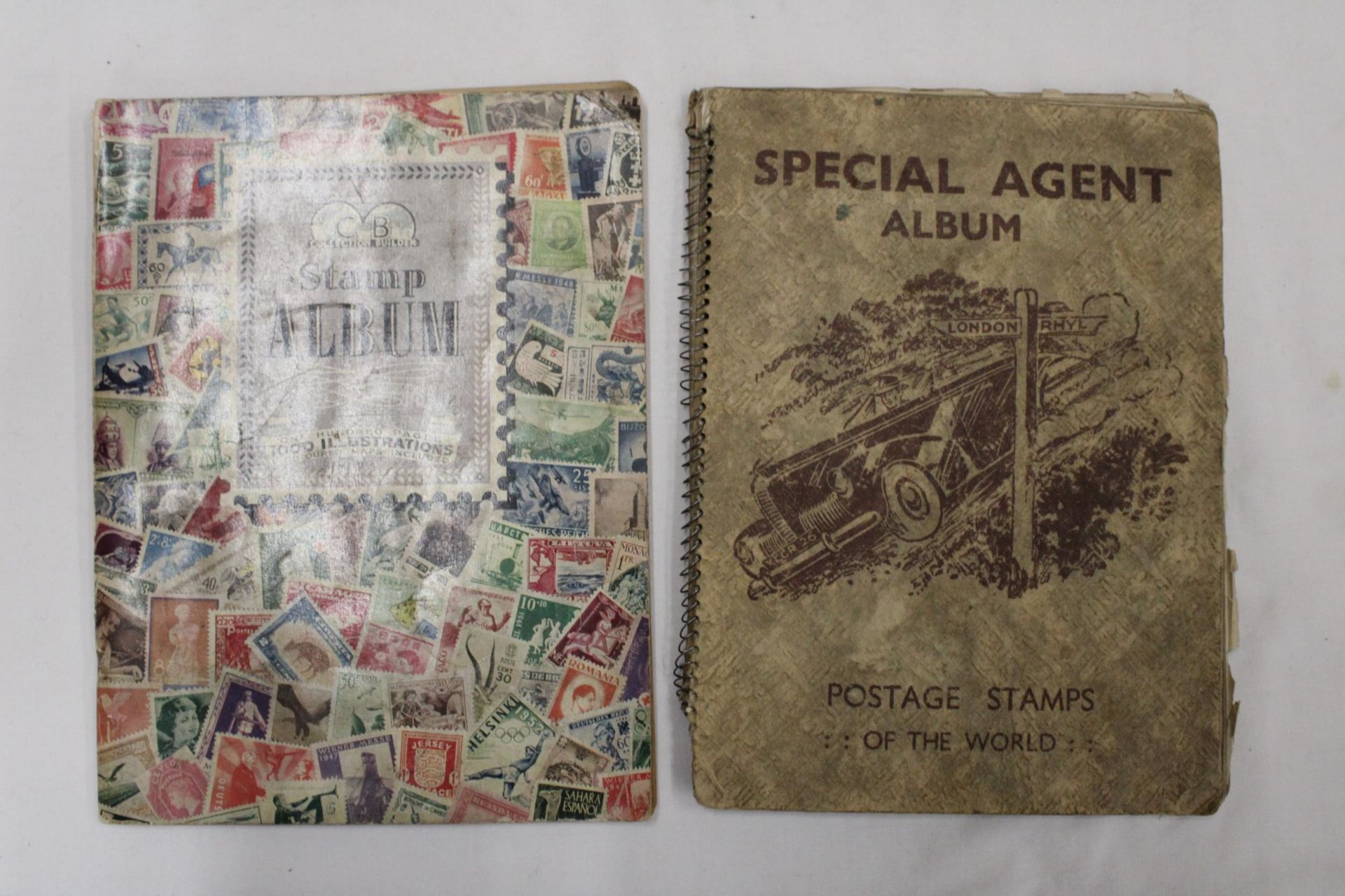 TWO OLD ALBUMS CONTAINING STAMPS FROM AROUND THE WORLD