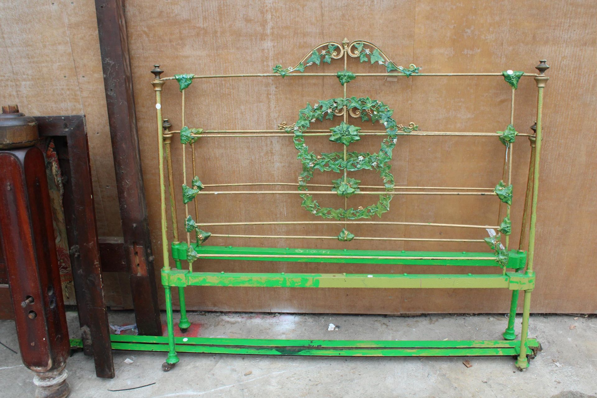 A BRASS AND IRON 4'6" BEDSTEAD DECORATED WITH LEAVES