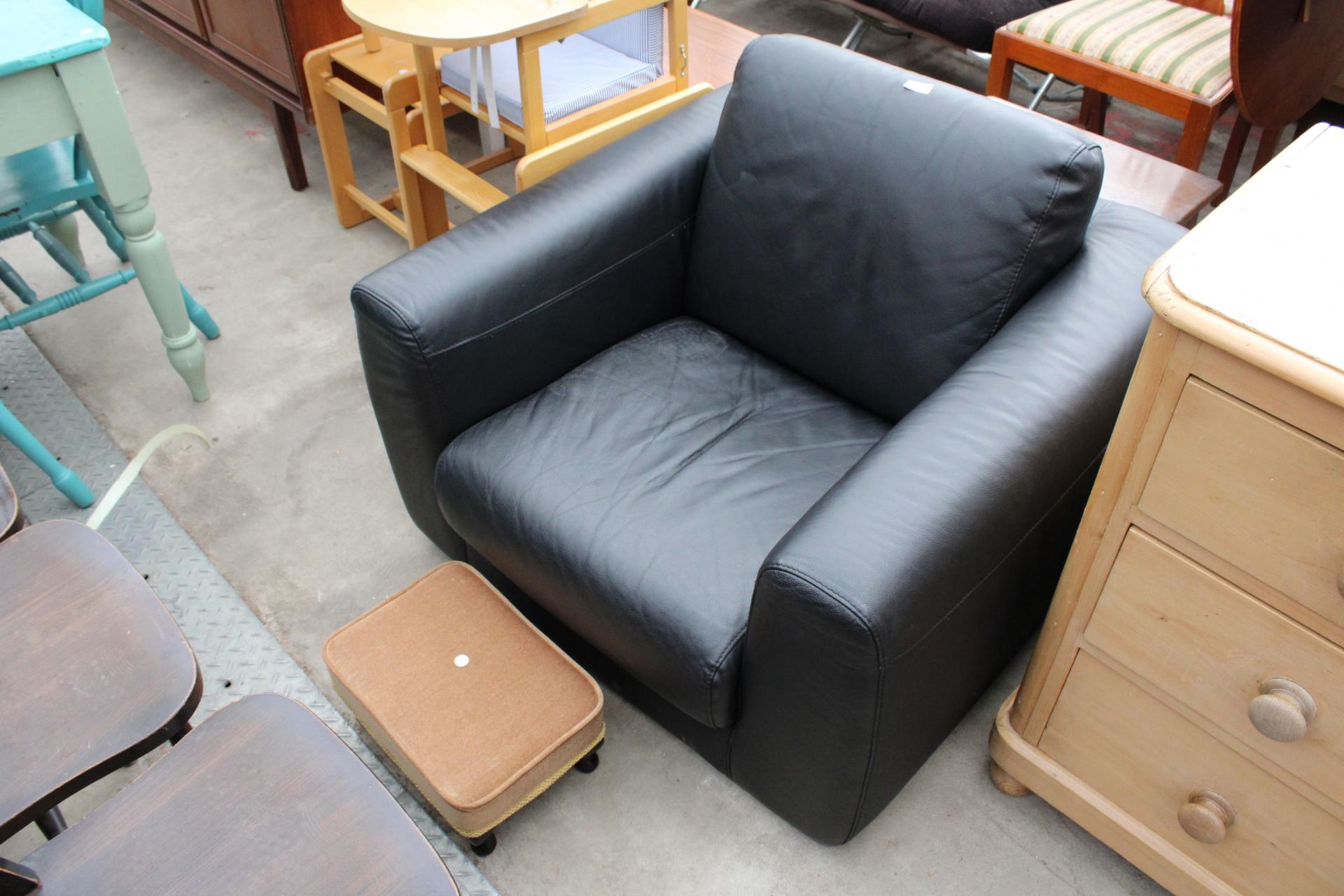 A MODERN HABITAT BLACK FAUX LEATHER EASY CHAIR AND MISS MUFFET STOOL