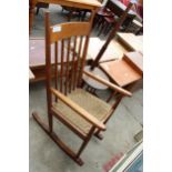 A MID 20TH CENTURY HARDWOOD ROCKING CHAIR WITH DROP-IN WOVEN SEAT