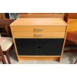 A MODERN SIDE CABINET ENCLOSING TWO DRAWERS AND TWO BLACK PAINTED CUPBOARDS, 33" WIDE