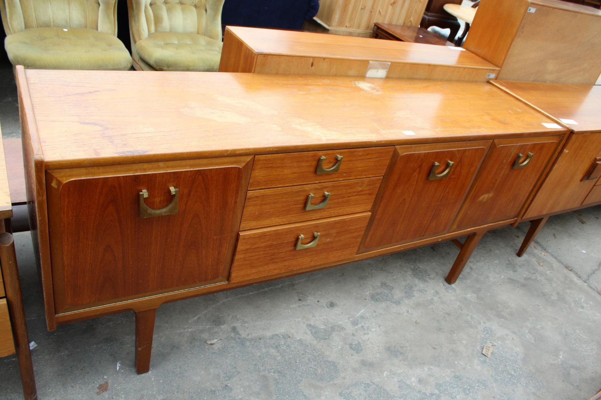A RETRO TEAK SIDEBOARD WITH BRASS HANDLES ENCLOSING THREE DRAWERS AND THREE CUPBOARDS, 72" WIDE
