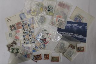 A QUANTITY OF STAMPS IN PACKETS FROM AROUND THE WORLD