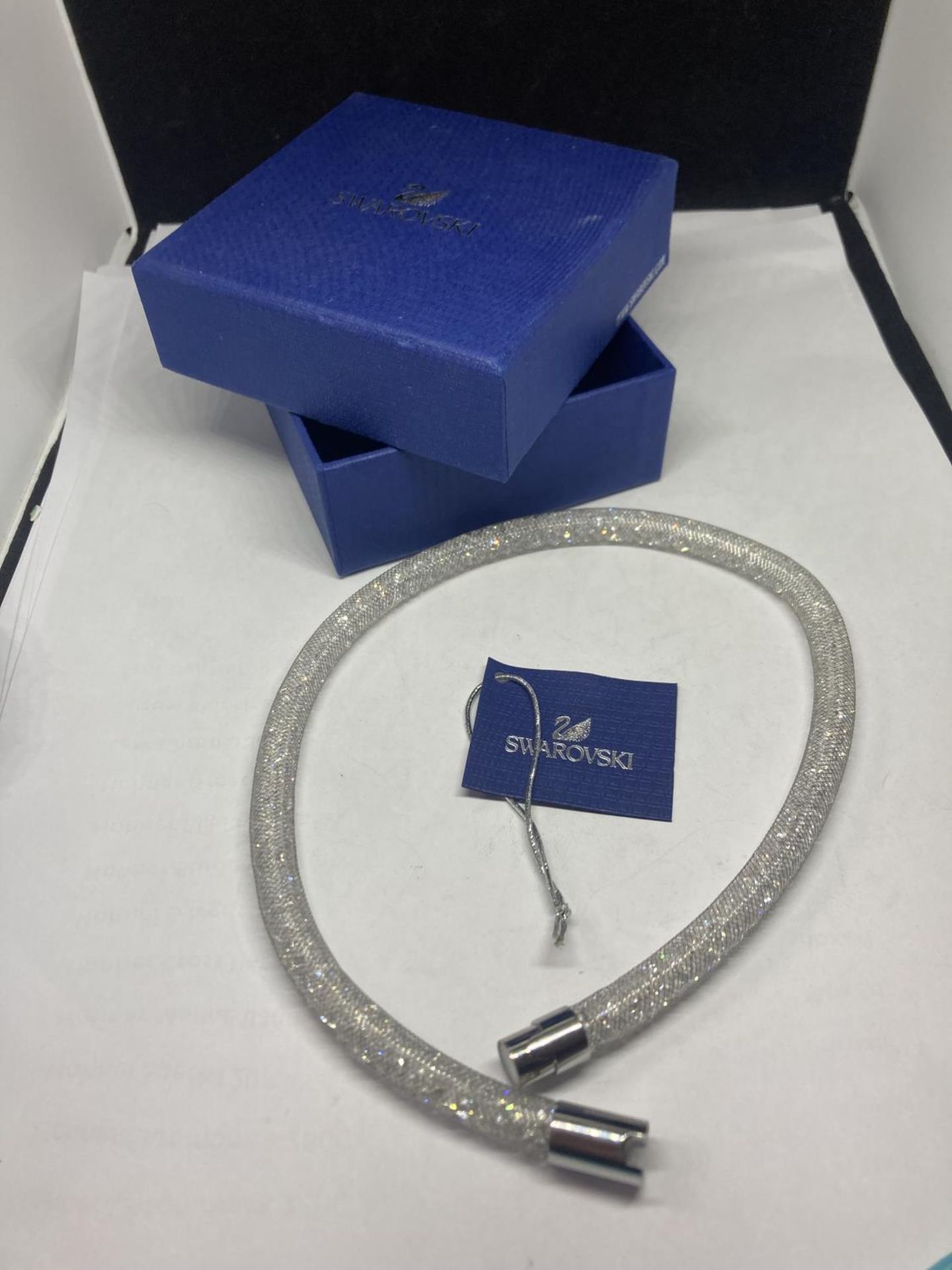 A SWAROVSKI CRYSTAL SILVER COLOURED STARDUST BRACELET IN ORIGINAL PRESENTATION BOX WITH TAG