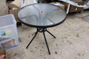 A ROUND METAL AND GLASS TOPPED BISTRO TABLE