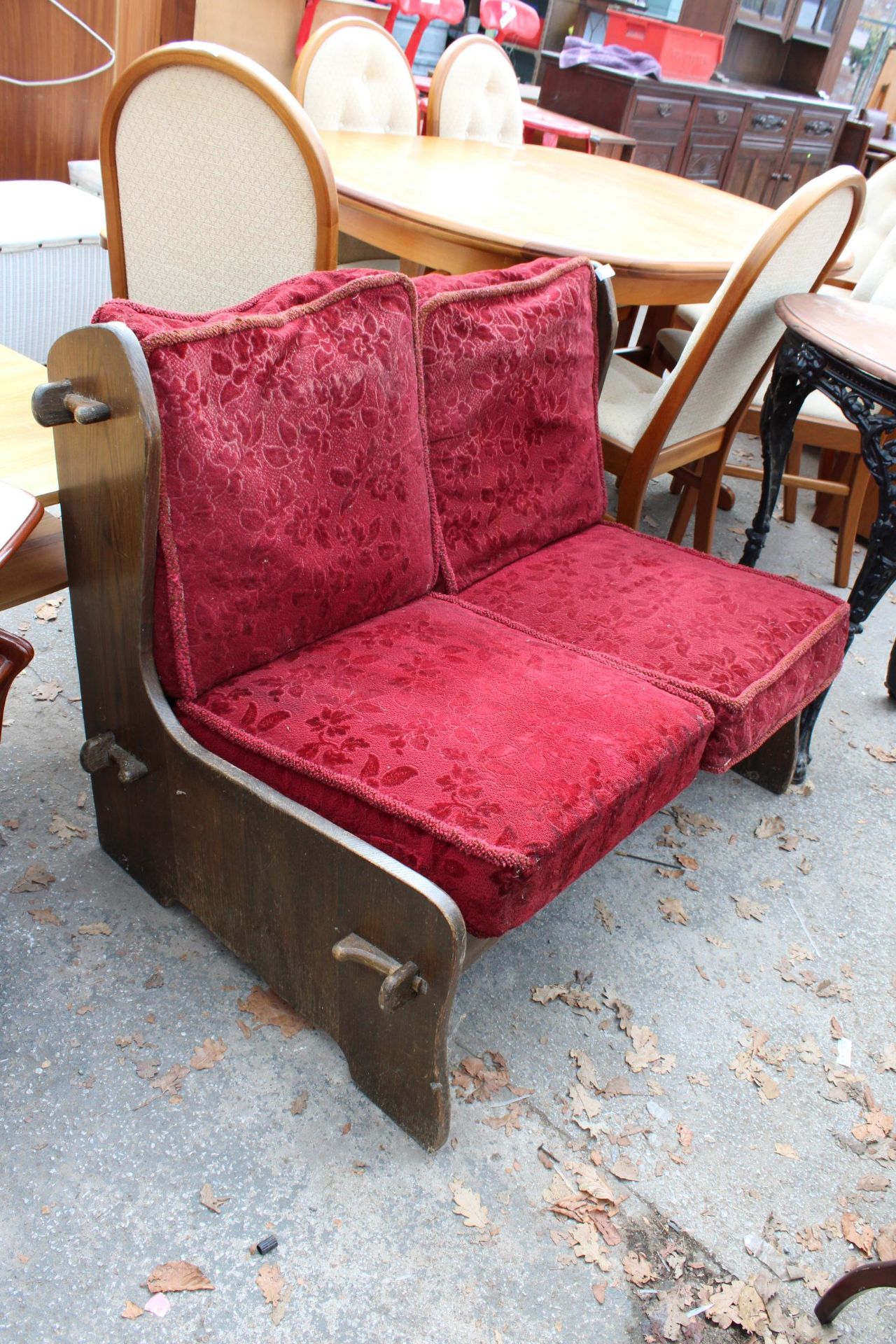 AN OAK FRAMED SETTLE WITH CUSHIONS