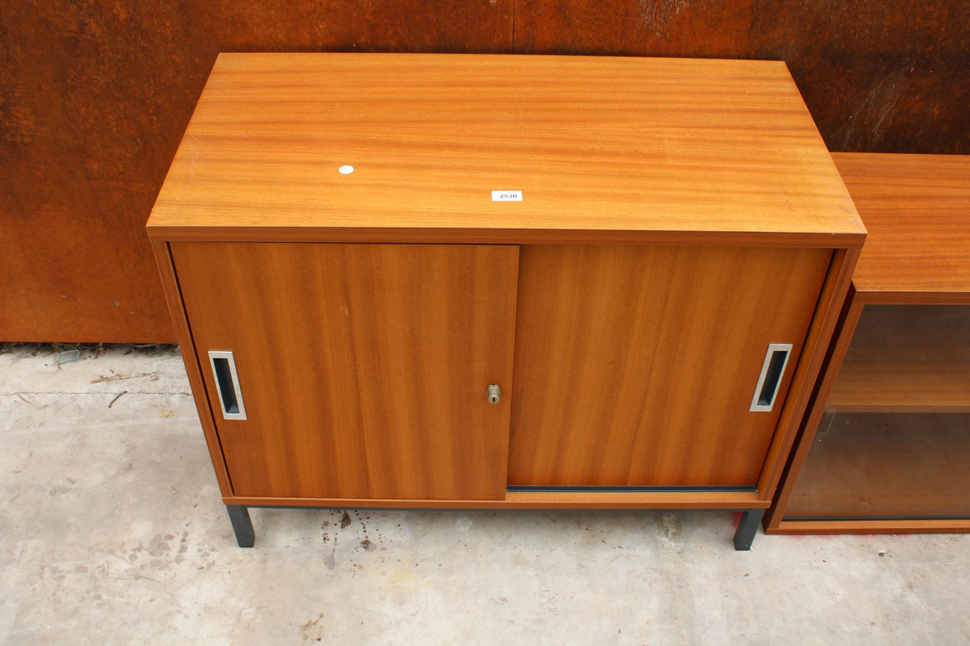 A RETRO TEAK STORAGE CUPBOARD WITH TWO SLIDING DOORS 35.5" WIDE