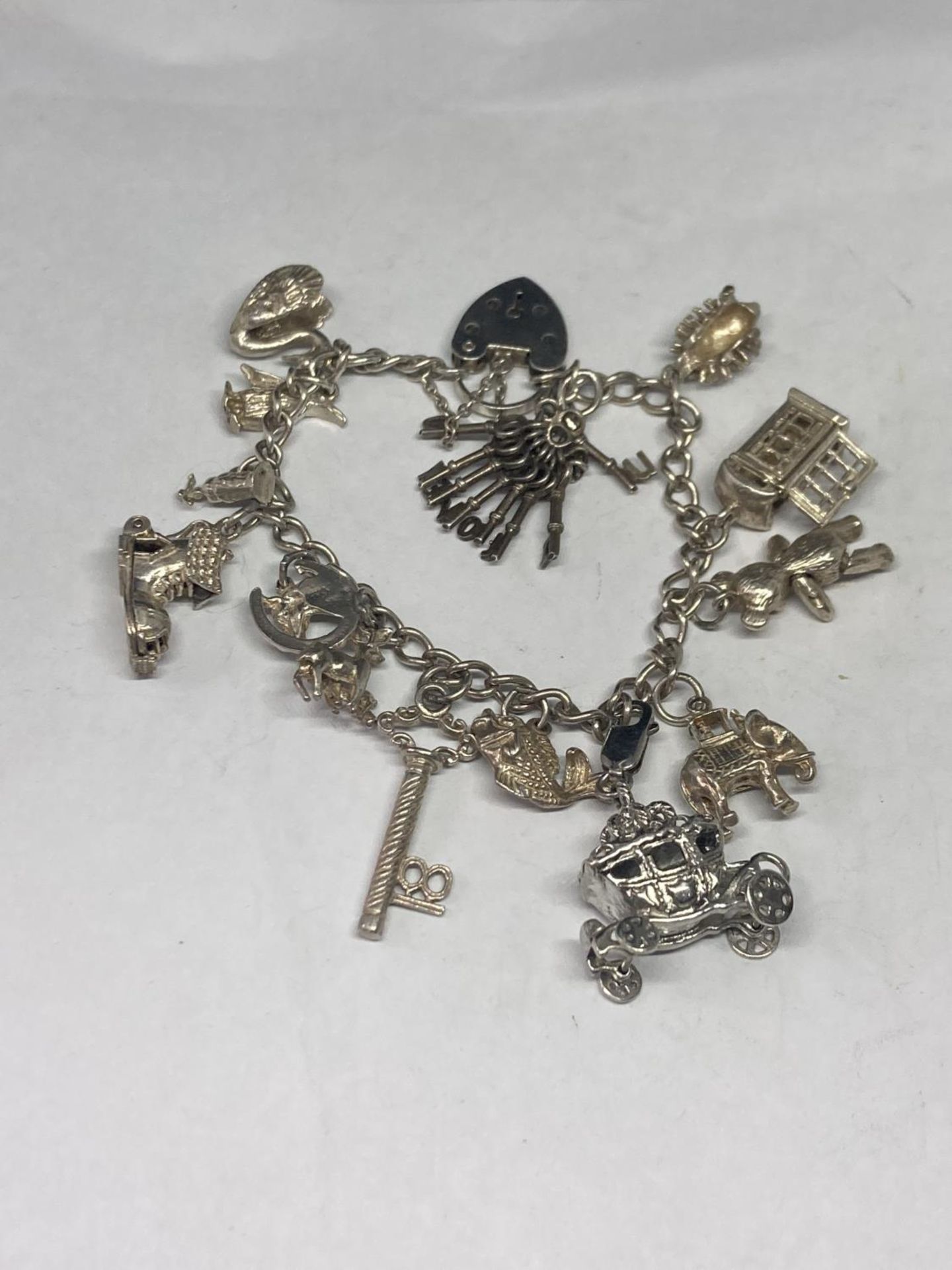 A SILVER CHARM BRACELET WITH FOURTEEN CHARMS