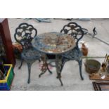 A VINTAGE STYLE CAST METAL BISTRO SET COMPRISING OF A ROUND TABLE AND TWO CHAIRS