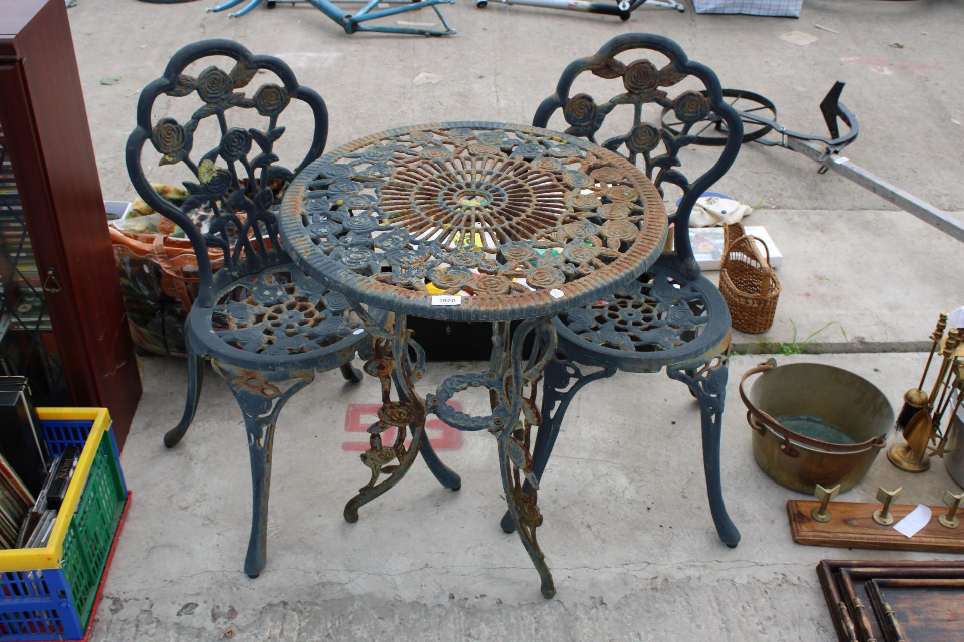 A VINTAGE STYLE CAST METAL BISTRO SET COMPRISING OF A ROUND TABLE AND TWO CHAIRS