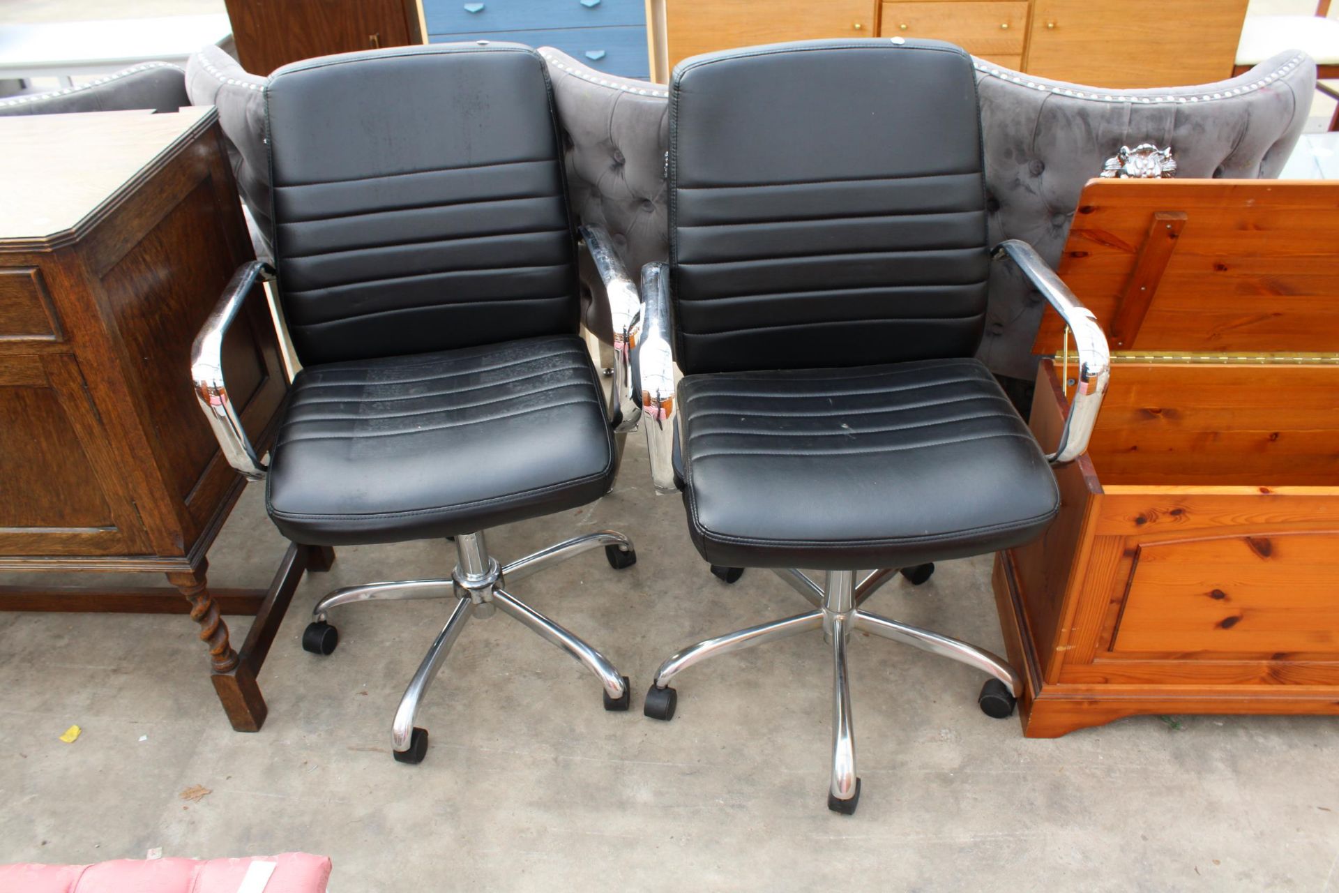 A PAIR OF COSTCO SWIVEL DESK CHAIRS WITH POLISHED CHROME ARMS AND BASES