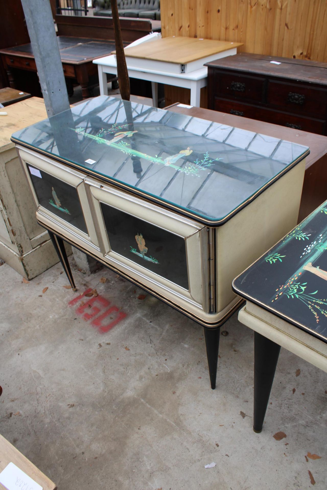 A 1960'S ITALIAN TWO DOOR SIDE CABINET ON BLACK TAPERING LEGS WITH CHINOISERIE DECORATION WITH