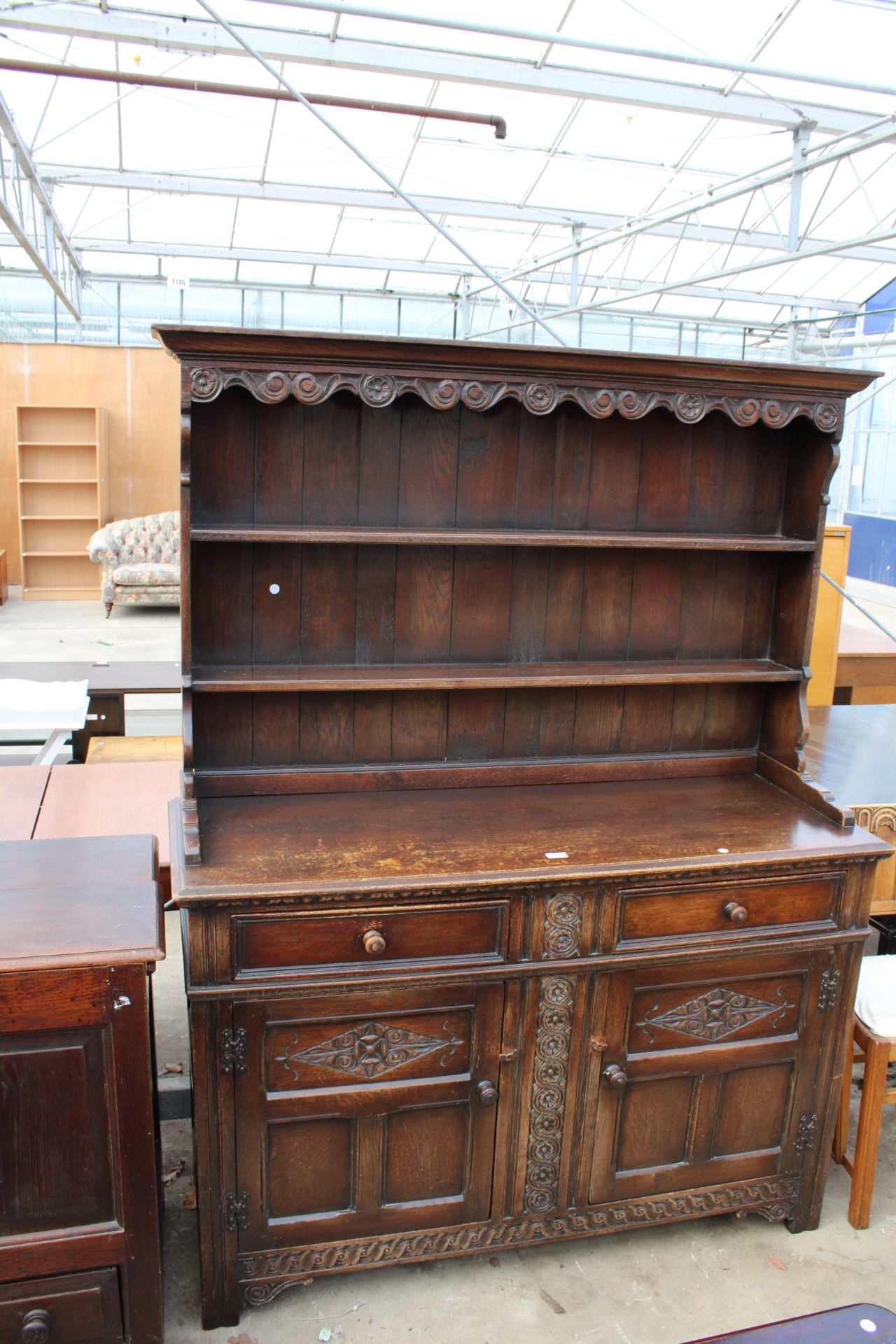 AN OAK JACOBEAN STYLE DRESSER WITH CARVED PANELS AND PLATE RACK, 56" WIDE