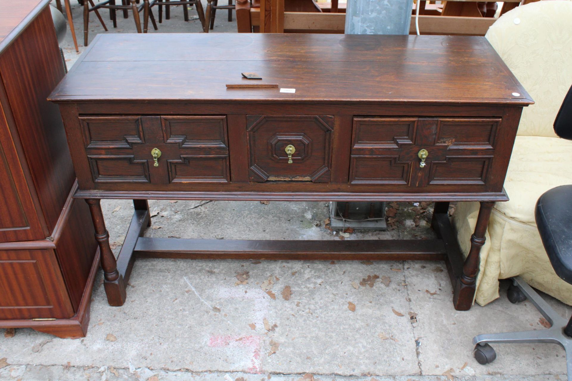 AN OAK JACOBEAN STYLE THREE DRAWER DRESSER BASE ON TURNED LEGS, 49.5" WIDE