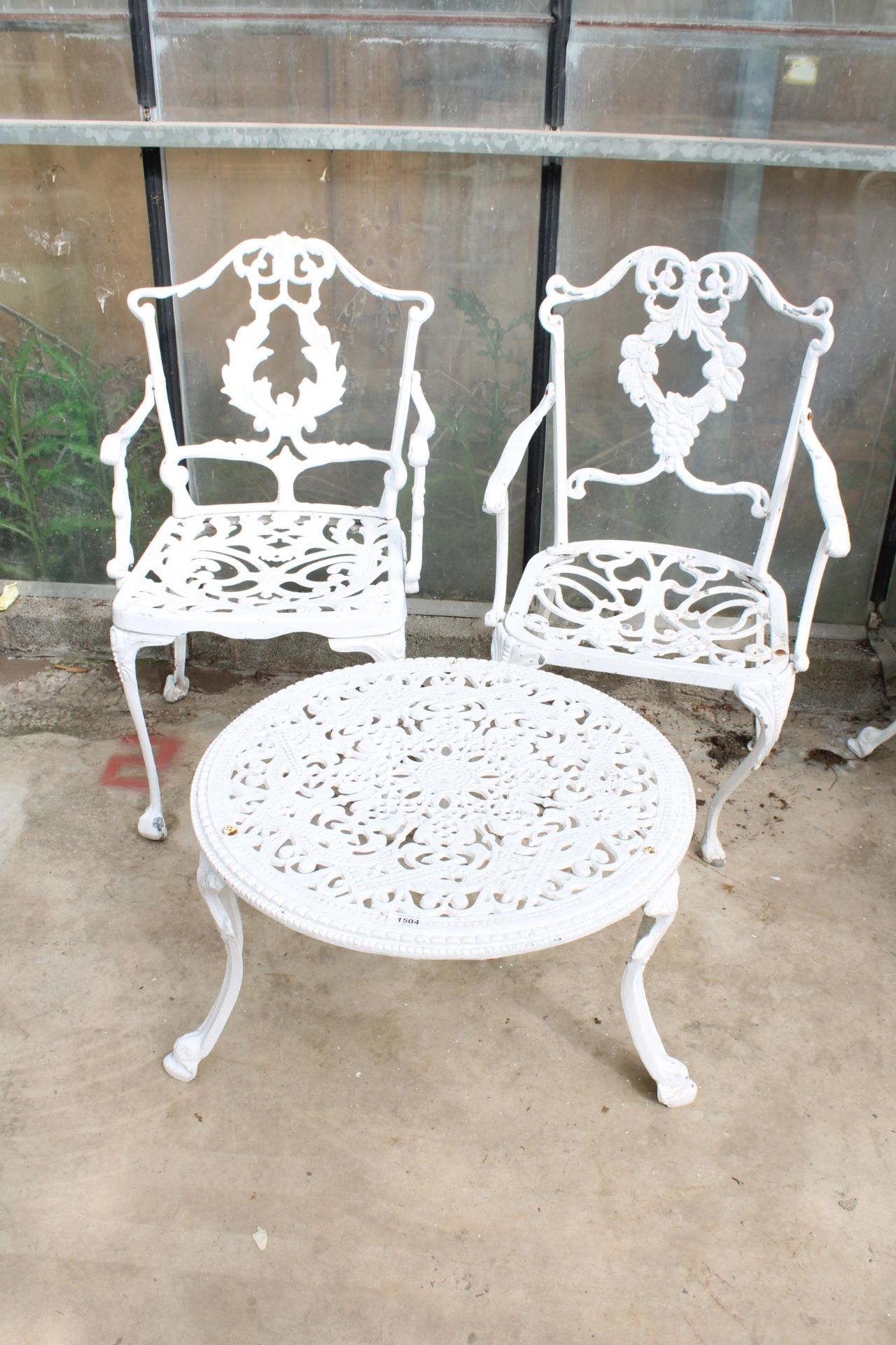 A CAST ALLOY FURNITURE SET COMPRISING OF A ROUND COFFEE TABLE AND TWO CARVER CHAIRS