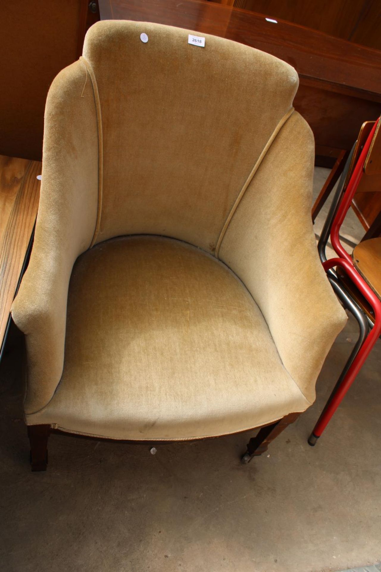 AN EDWARDIAN UPHOLSTERED LOUNGE CHAIR ON MAHOGANY AND INLAID TAPERING FRONT LEGS