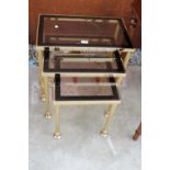 A MODERN GOLD COLOURED METAL FRAMED NEST OF 3 TABLES WITH SMOKED GLASS TOP