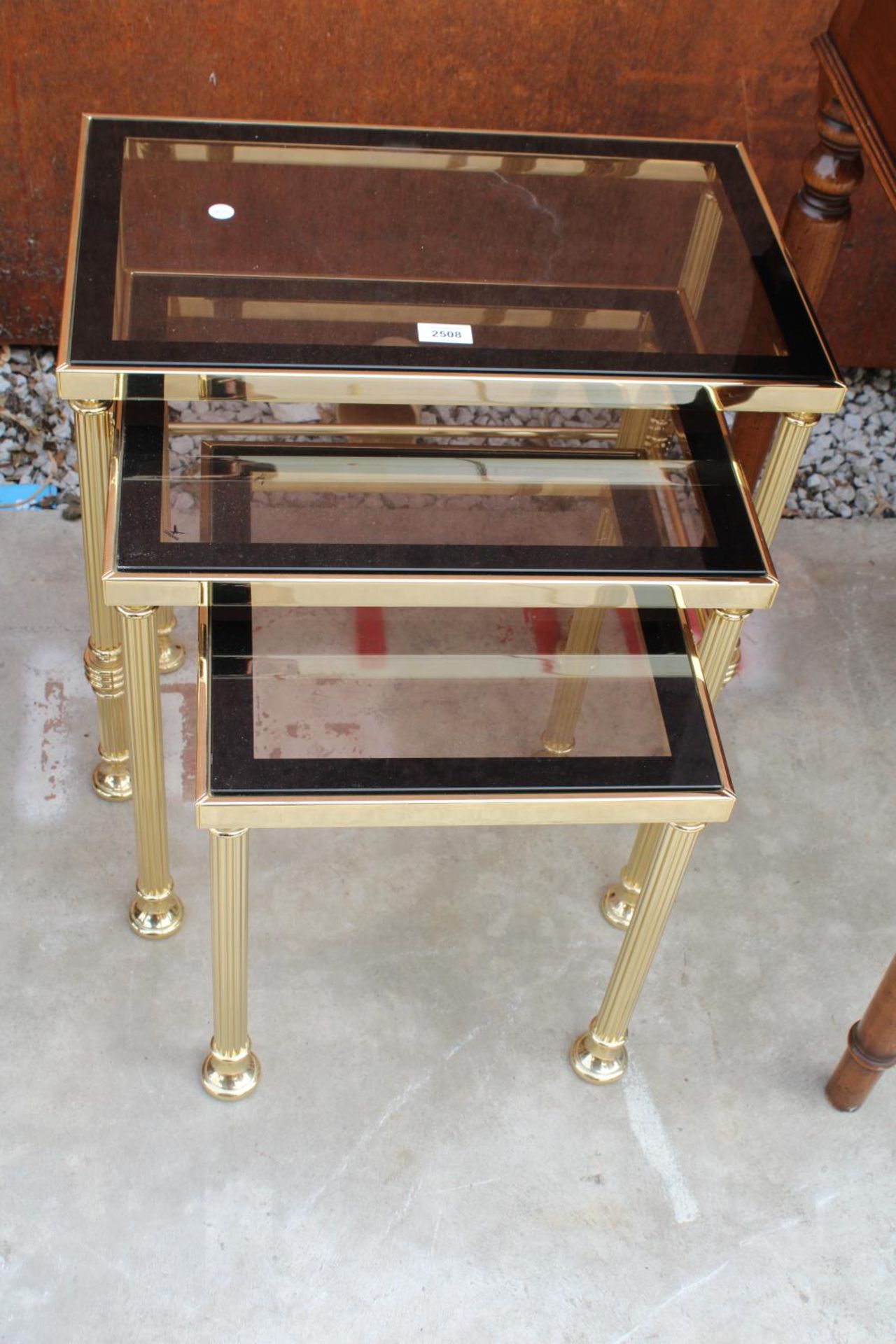 A MODERN GOLD COLOURED METAL FRAMED NEST OF 3 TABLES WITH SMOKED GLASS TOP