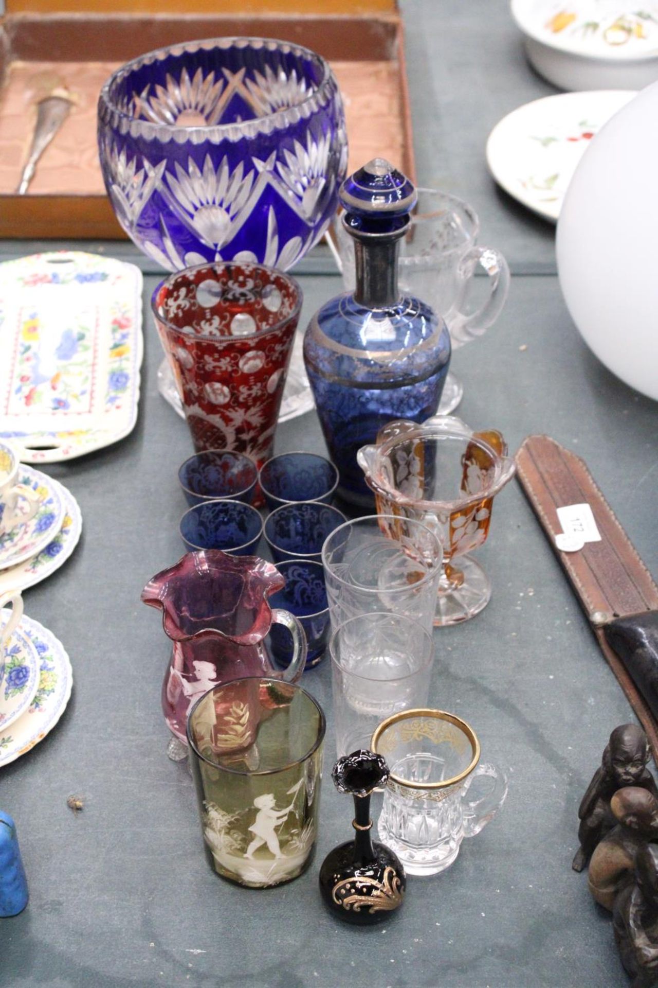 A MIXED LOT OF GLASSWARE TO INCLUDE A BLUE BOHEMIAN STYLE VASE, CRANBERRY JUG, SIX SHOT GLASSES ETC