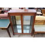 A MODERN MAHOGANY DISPLAY CABINET WITH BEVELLED GLASS DOORS ON CABRIOLE LEGS, 36" WIDE