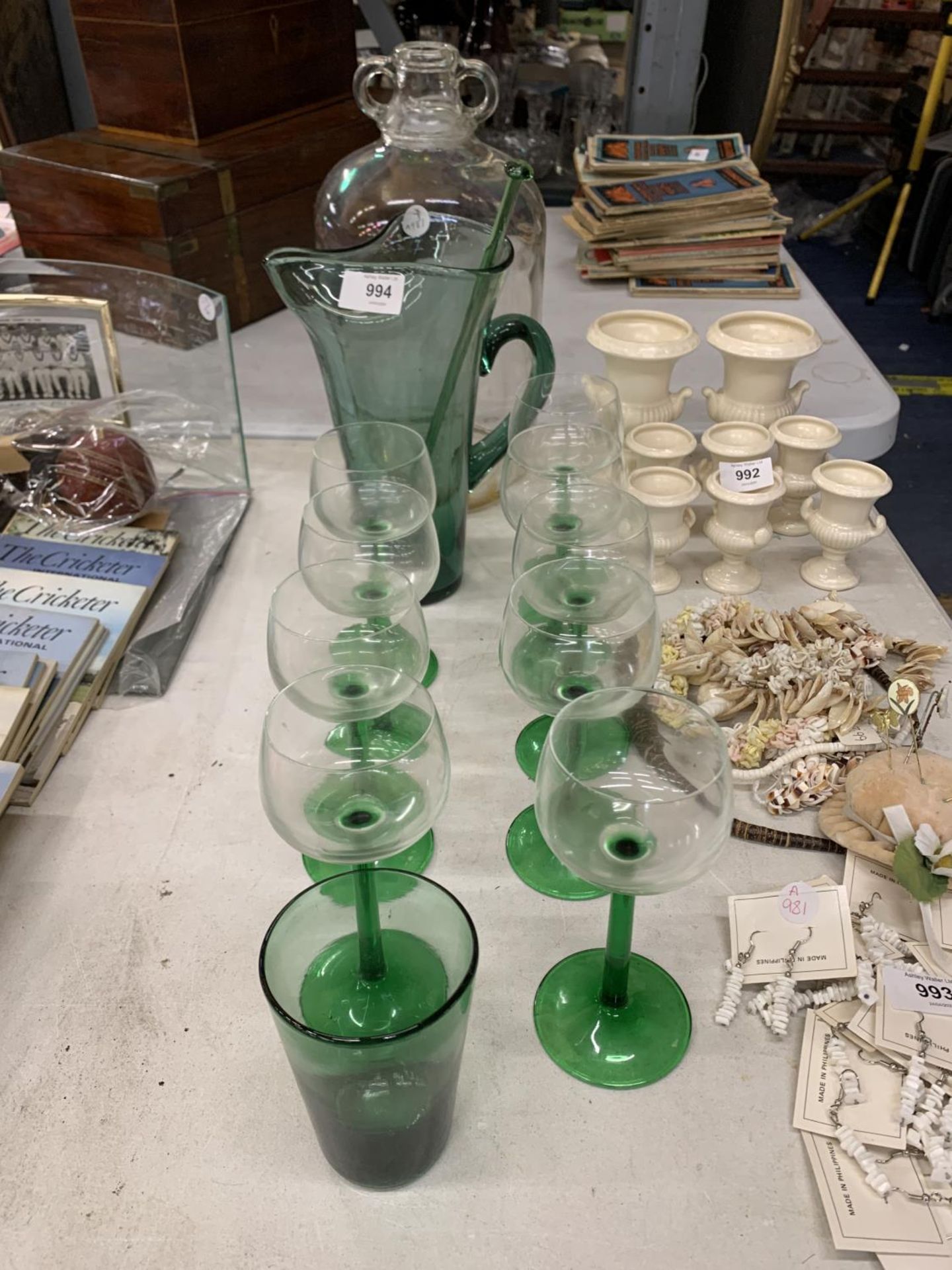 A GREEN LEMONADE JUG WITH GLASS SWIZZLE STICK, NINE WINE GLASSES AND A DEMI-JOHN