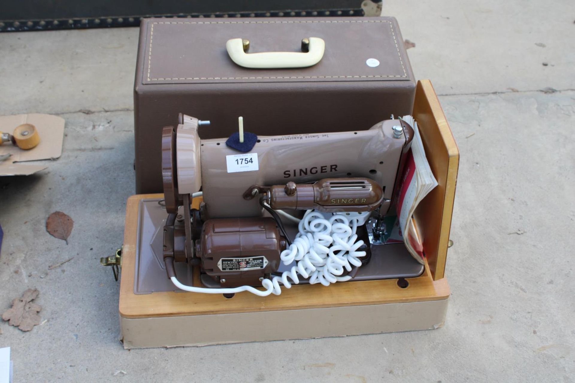 AN ELECTRIC SINGER SEWING MACHINE WITH FOOT PEDAL AND CARRY CASE