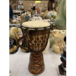 A WOODEN HAND CARVED BONGO DRUM