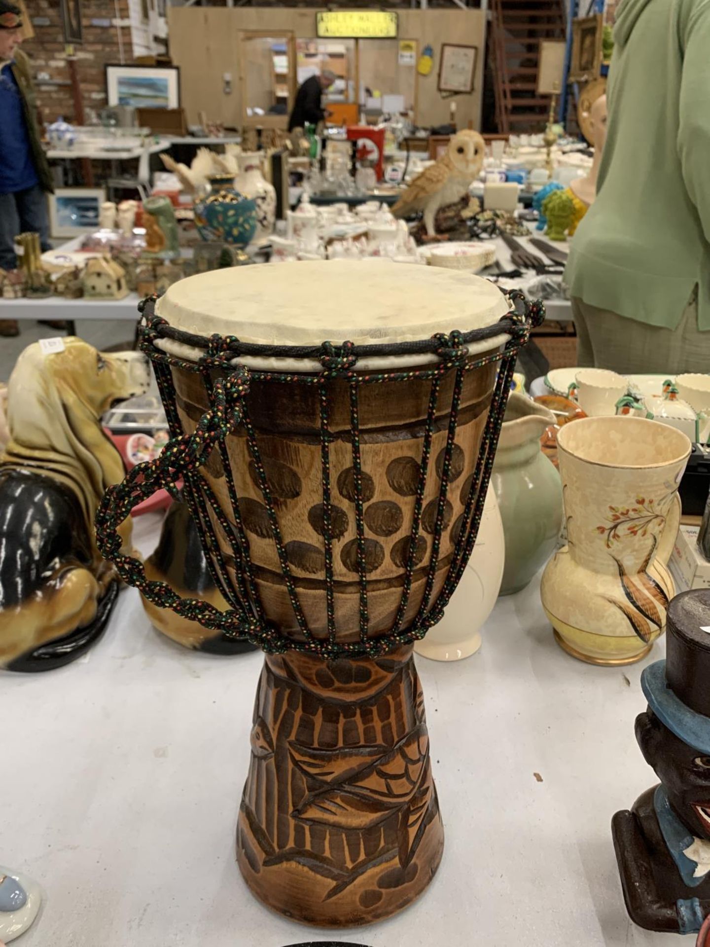 A WOODEN HAND CARVED BONGO DRUM
