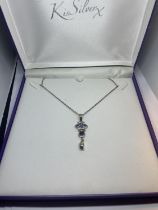 A SILVER NECKLACE IN A PRESENTATION BOX