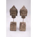A PAIR OF STONE BUDDHA HEADS ON STANDS