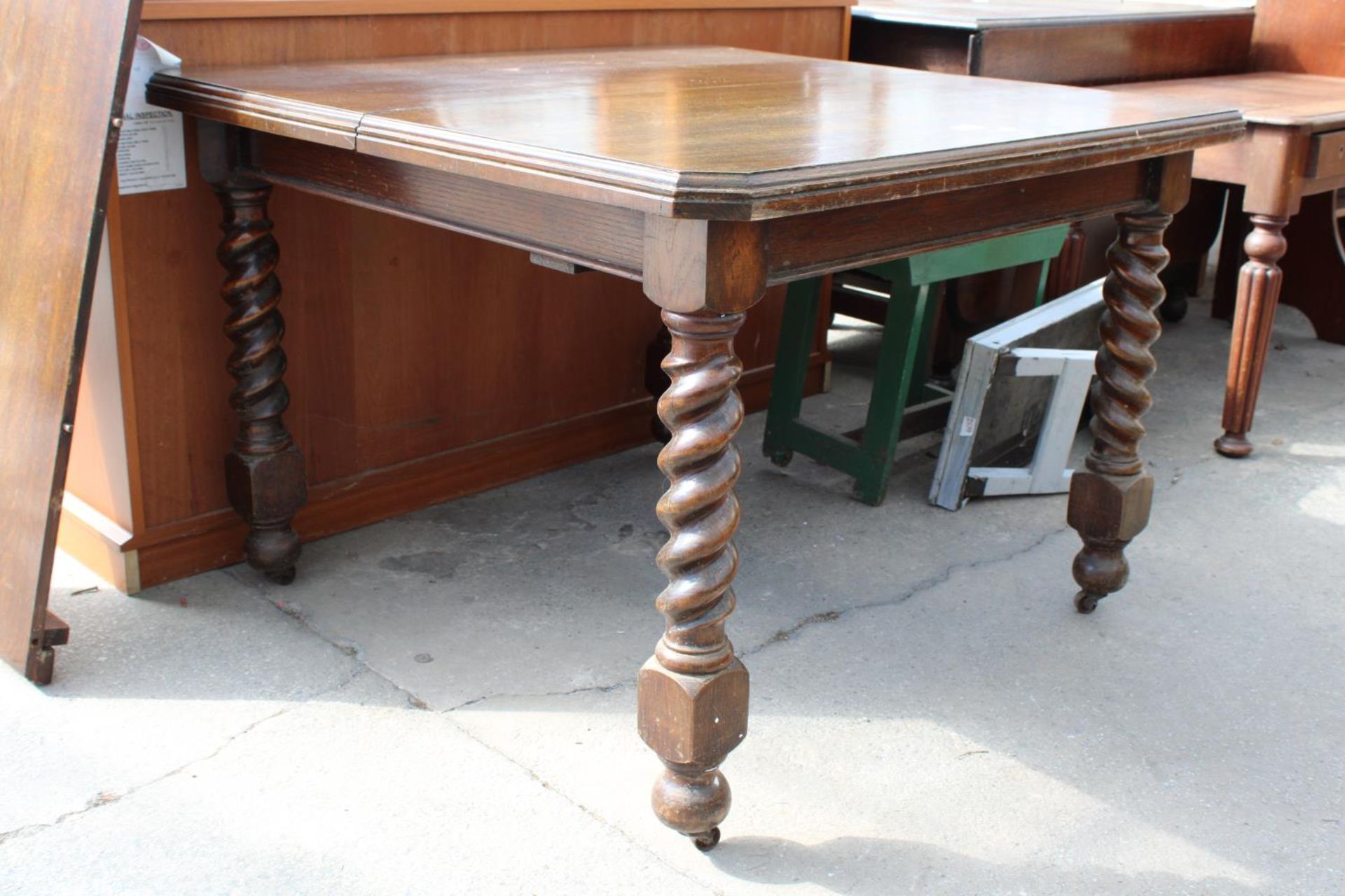 AN EARLY 20TH CENTURY OAK EXTENDING DINING TABLE ON BARLEY-TWIST LEGS WITH CANTED CORNERS, 41" - Image 2 of 3