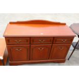 A MODERN CHERRY WOOD EFFECT SIDEBOARD ENCLOSING THREE DRAWERS AND THREE CUPBOARDS WITH RAISED