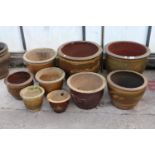 AN ASSORTMENT OF VARIOUS SIZED BROWN GLAZED GARDEN POTS, SOME DEPICTING DRAGONS