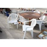 A TEAK GARDEN TABLE WITH SIX PLASTIC STACKING CHAIRS