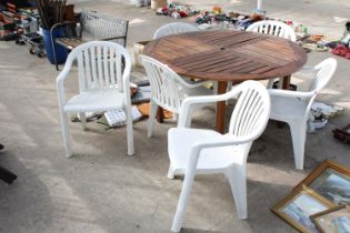 A TEAK GARDEN TABLE WITH SIX PLASTIC STACKING CHAIRS