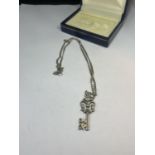 A SILVER KEY NECKLACE IN A PRESENTATION BOX