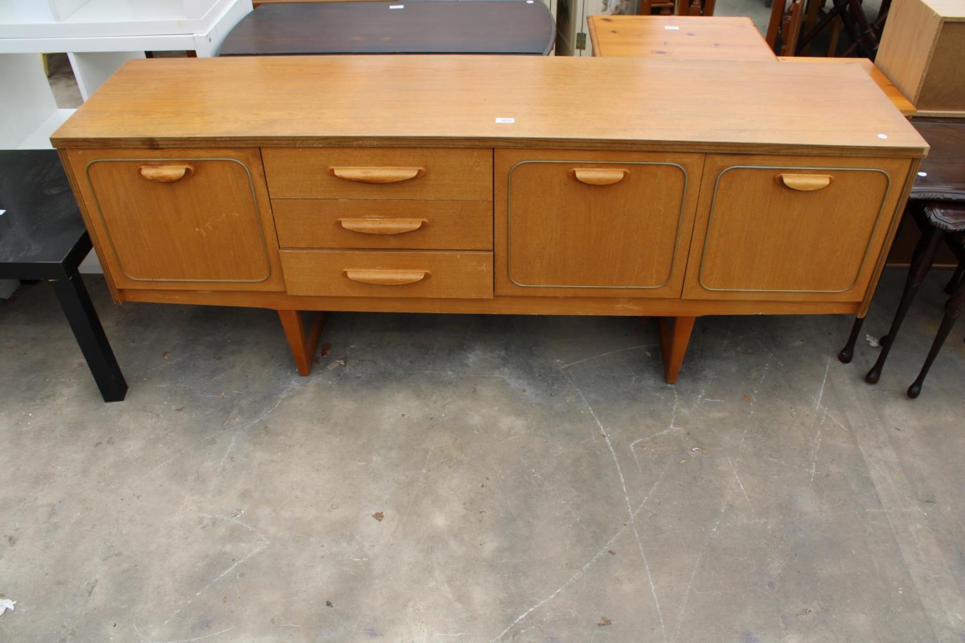 A RETRO TEAK SIDEBOARD ENCLOSING THREE DRAWERS AND THREE CUPBOARDS, 72" WIDE
