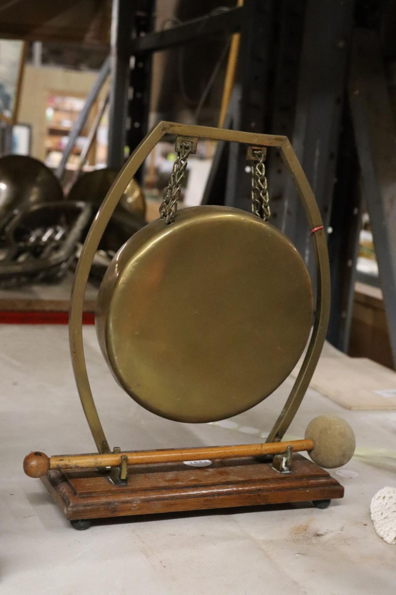 A BRASS TABLE TOP GONG WITH HAMMER - APPROXIMATELY 26CM HIGH