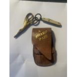 AN ANTIQUE PAIR OF MINIATURE SCISSORS IN A STORK DESIGN AND PEN KNIFE WITH A BROWN CASE LABELLED