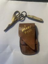 AN ANTIQUE PAIR OF MINIATURE SCISSORS IN A STORK DESIGN AND PEN KNIFE WITH A BROWN CASE LABELLED