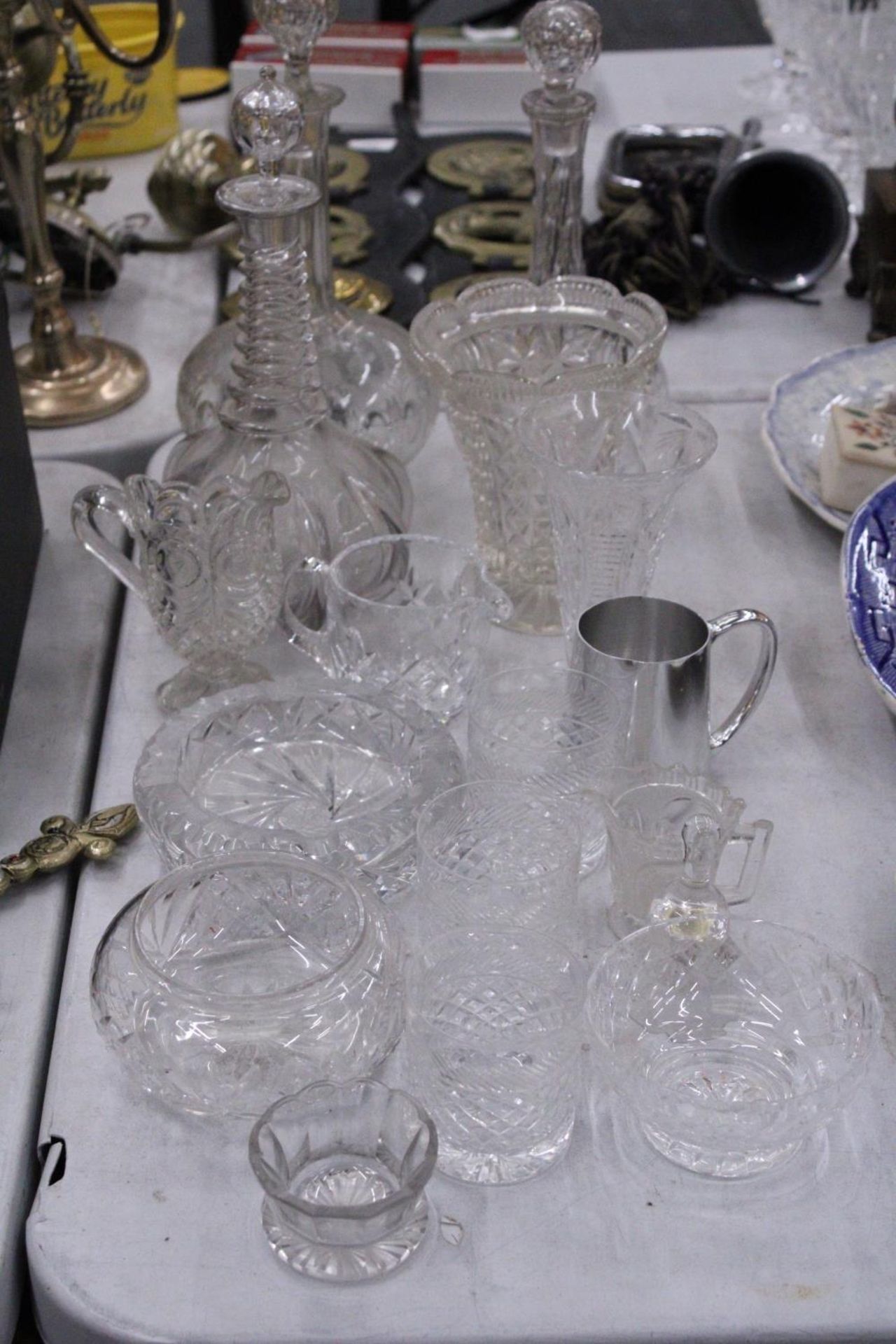 A QUANTITY OF GLASSWARE TO INCLUDE DECANTERS, VASES, JUGS, BOWLS, ETC
