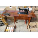 A VINTAGE SEWING TABLE WITH SINGER SEWING MACHINE BELIEVED IN WORKING ORDER BUT NO WARRANTY