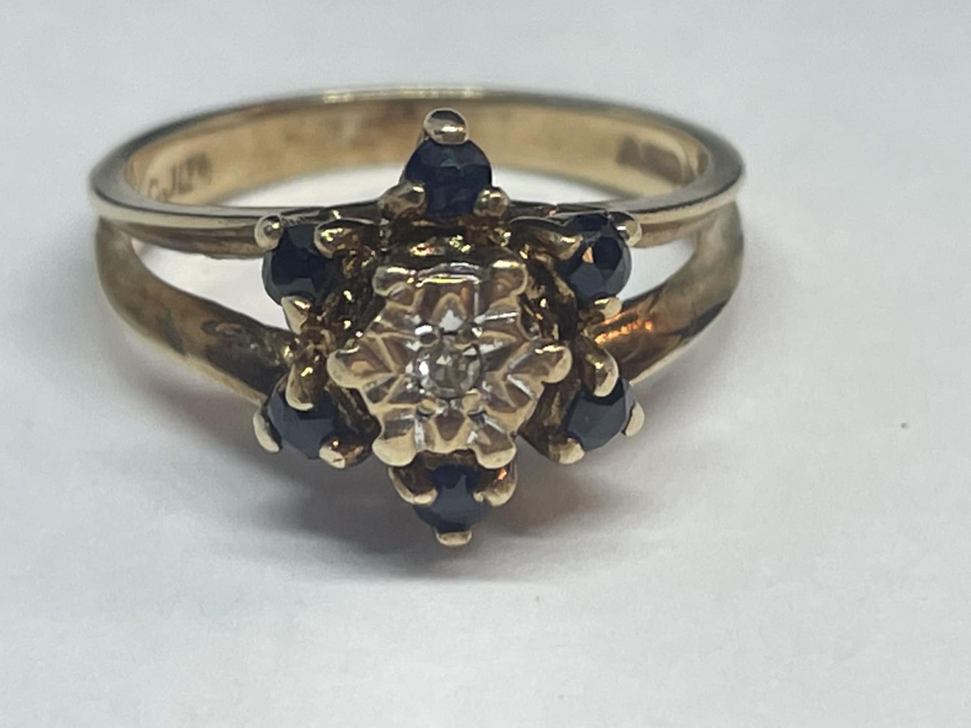 A 9 CARAT GOLD RING WITH A CLUSTER OF DIAMONDS AND SAPPHIRES SIZE K/L