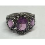A SILVER RING WITH AMETHYST COLOURED STONES