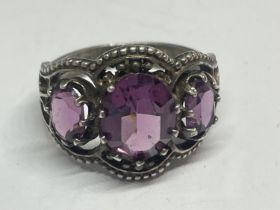 A SILVER RING WITH AMETHYST COLOURED STONES