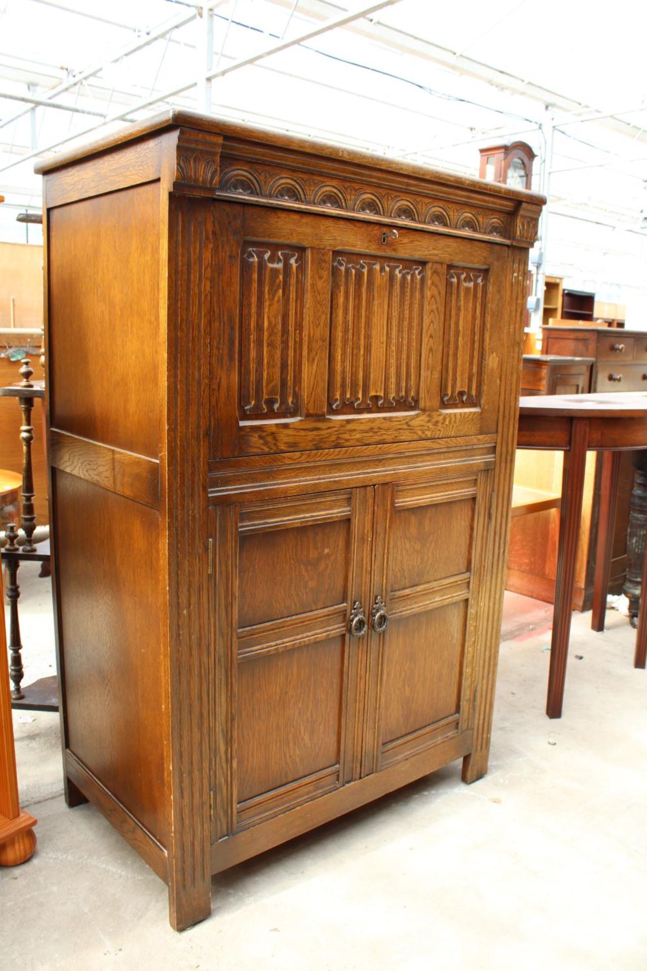 AN OAK CHARM STYLE COCKTAIL CABINET WITH LINEN-FOLD DROP DOWN FRONT AND CUPBOARD TO BASE, 31.5" WIDE - Image 2 of 4