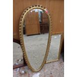 A MODERN GILT FRAMED PERRY OVERMAN (GLOVE) WALL MIRROR, 48" X 21"