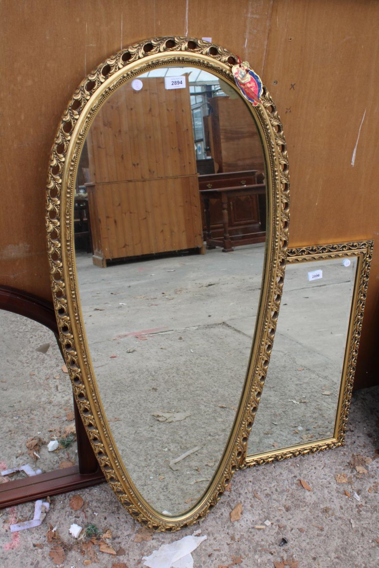 A MODERN GILT FRAMED PERRY OVERMAN (GLOVE) WALL MIRROR, 48" X 21"